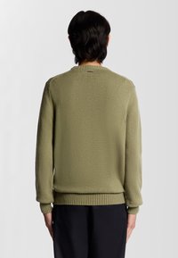 Pull en tricot vert avec des poignets et un ourlet côtelés. Doté d'un tissu texturé avec une coupe décontractée, un dos uni et un col rond.