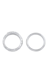 Zwei silberne Ringe: einer hat ein strukturiertes, gehämmertes Design mit kleinen Perlenakzenten, während der andere ein glattes, poliertes Band ist.