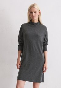 Abito grigio scuro a maniche lunghe con colletto alto, realizzato in morbido tessuto a maglia, caratterizzato da una vestibilità ampia e maniche arrotolate.
