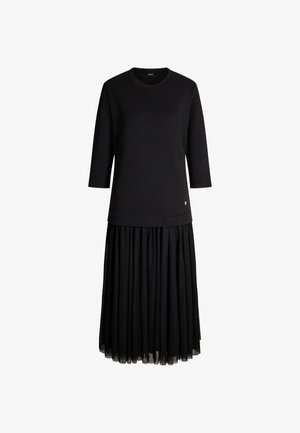 Zwarte jurk met een gestructureerde bovenkant en een geplooide, vloeiende rok. Driekwartmouwen en subtiele logo-details nabij de zoom.