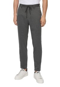 Graue, bequeme Sweatpants mit Drawstring verfügen über ein tailliertes Design und sind aus einem weichen, strukturierten Stoff gefertigt, kombiniert mit weißen Sneakers.