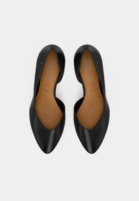 Μαύρες δερμάτινες μπαλαρίνες με μυτερή μύτη και χαμηλό κόψιμο, με λεία υφή και μπεζ σόλα που φέρει το όνομα της μάρκας.