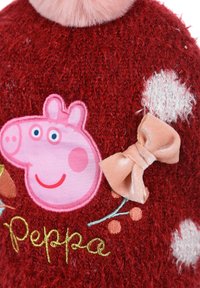 Jersey de punto rojo con un aplique de Peppa Pig en rosa, un cuello de piel sintética rosa y un lazo de satén melocotón con acentos bordados y puntos blancos.