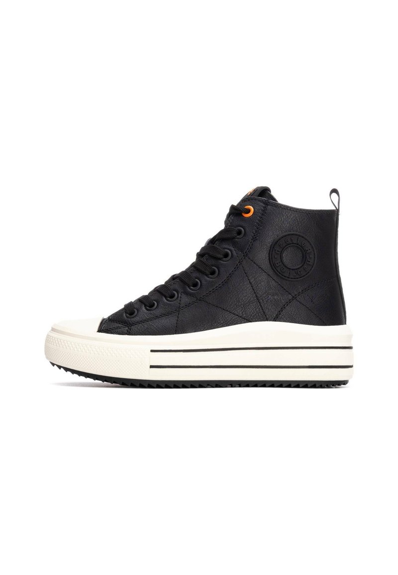 Zapatilla alta negra con material de cuero texturizado, suela de goma blanca, acentos a rayas en blanco y negro, y un detalle de ojal naranja.