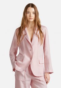 Blazer de lino rosa claro con dos bolsillos delanteros, solapas de pico y dos botones, que presenta un corte relajado y una superficie ligeramente texturizada.