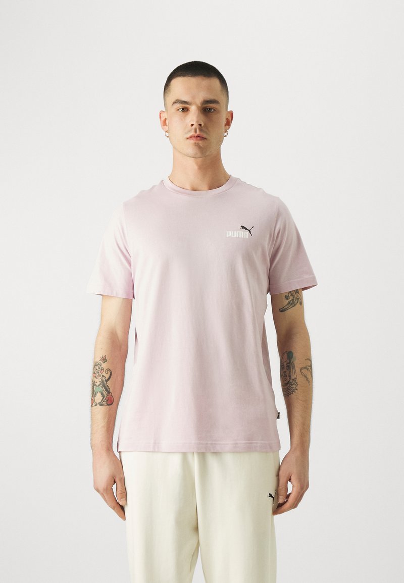 Camiseta de algodón rosa claro con mangas cortas, escote redondo, pequeño logo negro de Puma en el pecho y un ajuste relajado.