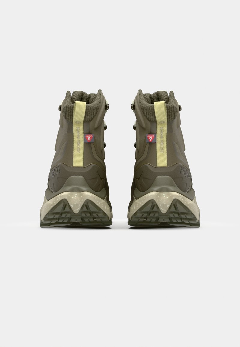 Donkergroene wandelschoenen met een gebreide kraag, versterkte veterogen en een gestructureerde zool met een opvallend profiel.