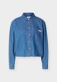 Μπλε τζιν πουκάμισο με μακριά μανίκια, κουμπιά, γιακά και τσέπη στο στήθος που φέρει ένα μικρό ταμπελάκι με το λογότυπο Calvin Klein.