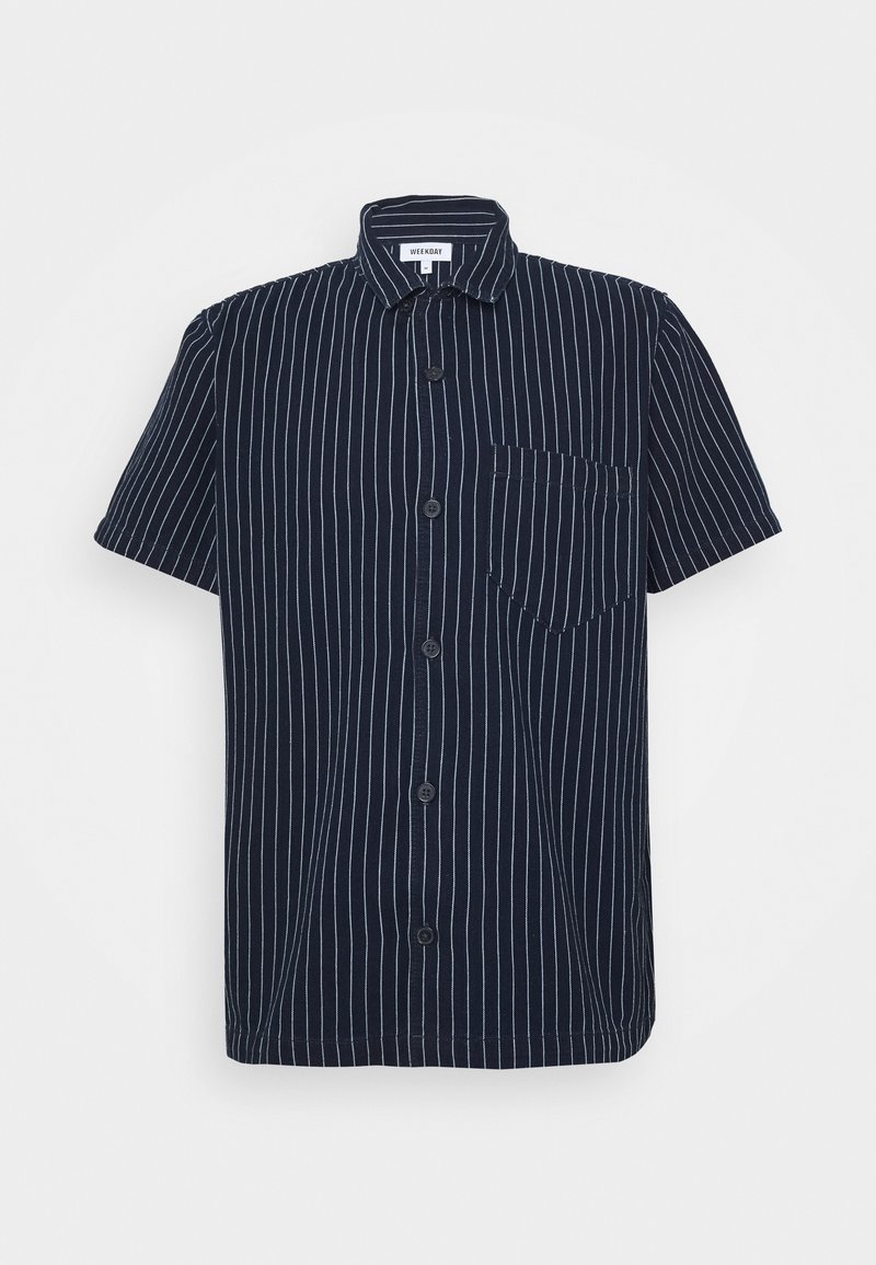 Chemise bleu marine à manches courtes avec boutons, rayures verticales blanches et une poche poitrine sur le côté gauche.