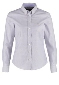 Skjorta med knappar och långa ärmar, blå och vita vertikala ränder, krage, liten logotyp på vänster bröst och slät tygkvalitet.