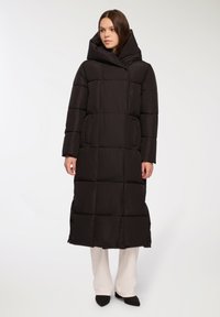 Czarny długi pikowany płaszcz z kapturem, z bocznymi kieszeniami i prostym krojem o gładkiej teksturze.