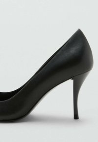 Décolleté nera con tacco alto, realizzata in pelle liscia e lucida, design a punta e tacco sottile e affusolato. Silhouette semplice ed elegante.