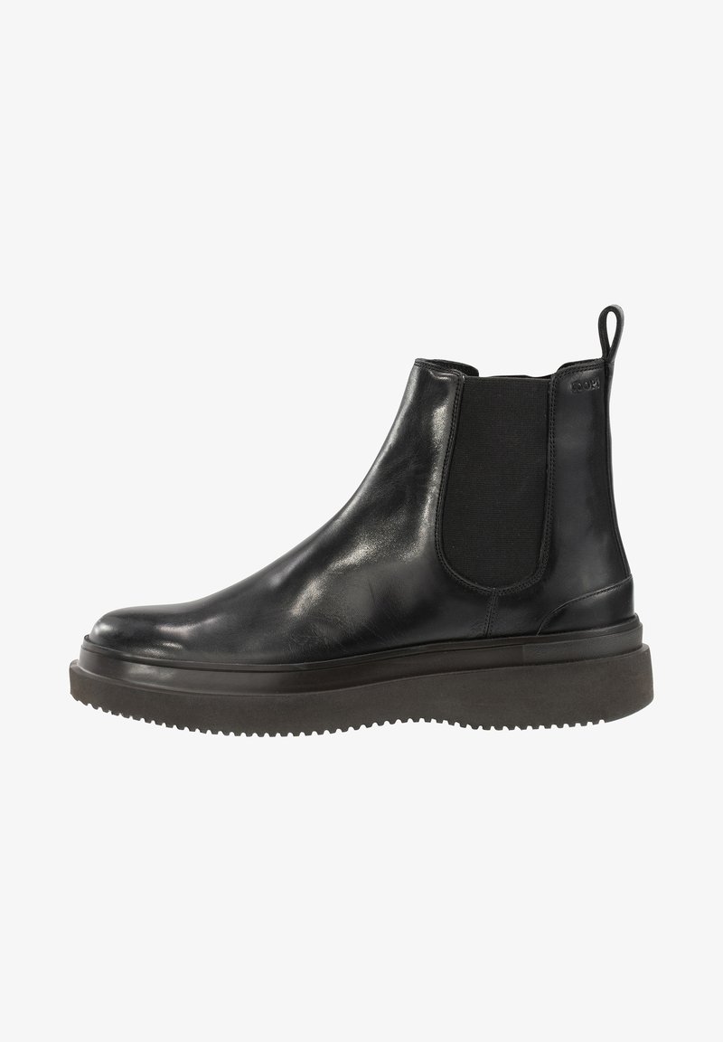 Botte Chelsea en cuir noir avec panneaux latéraux élastiques, semelle en caoutchouc épaisse et languette à l'arrière.