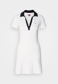 Bílé šaty s krátkým rukávem, černým límcem a výstřihem do V, úzký střih a malé logo Tommy Jeans na hrudi.