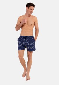 Blaue Bade shorts mit elastischem Bund, ausgestattet mit einem bunten Muster aus Eisbechern und Früchten, aus leichtem, schnell trocknendem Material gefertigt.