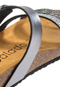Sandali con suola in sughero, dotati di cinturini metallici argentati e una tomaia strutturata, con una morbida soletta color beige e suola nera.