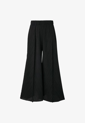 Pantalons noirs à jambes larges avec un design texturé et plissé, dotés d'une taille élastique. Le tissu est léger et fluide.