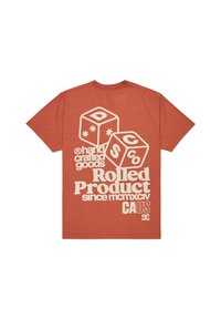 Camiseta de color óxido con una gran impresión en crema de dos dados y el texto "productos hechos a mano Producto Rodante desde MCMXCIV CA EE. UU." en la parte posterior.
