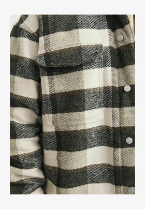 Koszula flanelowa w kratę w kolorze kremowym i ciemnozielonym. Wyposażona w kieszeń na piersi, guziki oraz miękki, strukturalny materiał.