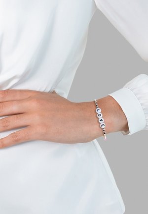 Perlenarmband mit weißen und schwarzen Buchstaben, die "LIEBE" buchstabieren, ausgestattet mit einem strukturierten, elastischen Band und kleinen bunten Akzenten.