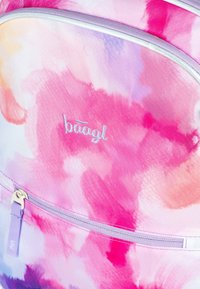 Zaino ad acquerello in tonalità pastello di rosa, viola e arancione. Presenta una tasca frontale con zip, un tirante viola e un logo in rilievo.