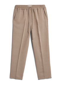 Beige volné kalhoty s elastickým pasem, šňůrkou, bočními kapsami a přímými nohavicemi položené na bílém pozadí.
