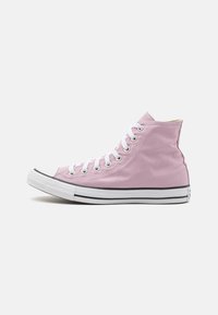 Zapatilla alta de lona rosa con cordones blancos, puntera de goma y una franja negra a lo largo de la suela. Textura suave con acentos mínimos.