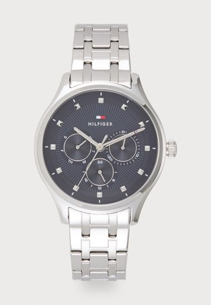 Montre en acier inoxydable argenté avec un cadran analogique bleu foncé, trois sous-dials et des accents argentés. Elle dispose d'un bracelet à maillons et d'indicateurs horaires marqués.