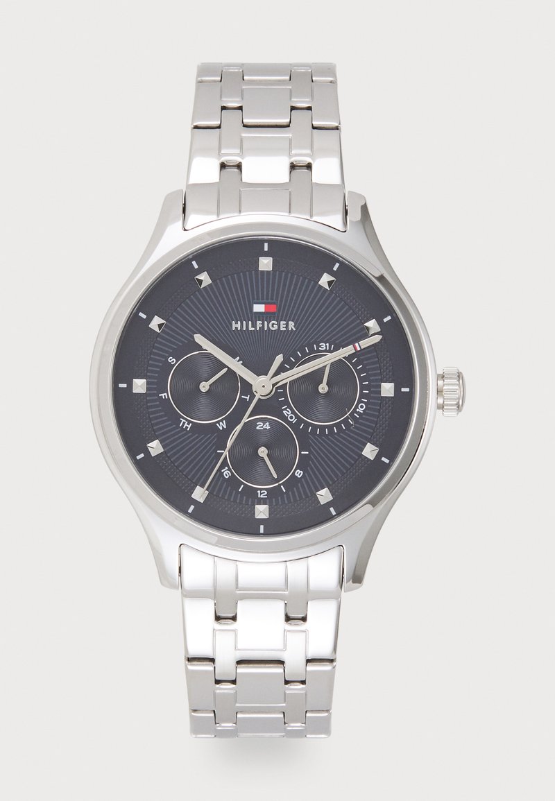 Montre en acier inoxydable argenté avec un cadran analogique bleu foncé, trois sous-dials et des accents argentés. Elle dispose d'un bracelet à maillons et d'indicateurs horaires marqués.