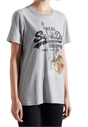 Person iført en grå T-shirt med et grafisk tryk af Frihedsgudinden og en tegneserie pizza slice med solbriller.