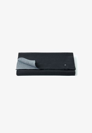 Couverture en textile pliée de couleur noire avec un dessous gris, dotée d'une texture lisse et d'un accent de bouton sur le bord.