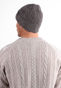 Béret tricoté gris avec un motif en cable texturé. Pull gris clair avec des motifs en côtes et en cable à l'arrière.