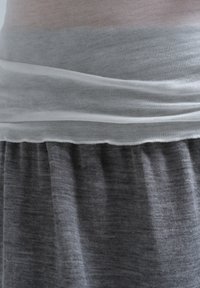 Grå og hvid lagdelt top med en blødt samlet grå bund. Stoffet ser let og lidt tekstureret ud med subtile farveovergange.