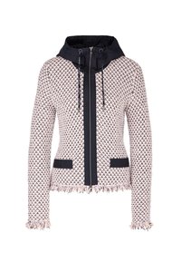 Veste en tricot texturé rose clair et noir avec fermeture éclair noire à l'avant, capuche à cordon de serrage, deux poches avant, et poignets et ourlet à franges.