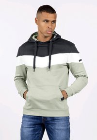 Sudadera con capucha de diseño a bloques de color; negro, blanco y verde oliva. Fabricada en tejido suave, con un bolsillo frontal y capucha con cordón.