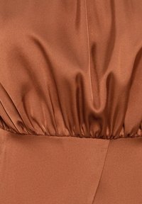 Tissu satin marron avec une taille froncée, texture lisse et léger éclat. Présente un design de couture épurée et une structure fluide.