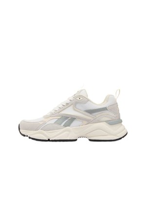 Baskets de sport blanches et gris clair avec une semelle épaisse, tige en mesh et en daim, lacets et languette au talon, visibles de profil.