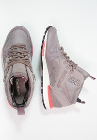 Graue High-Top-Sneaker aus Mesh und Wildleder, mit gepolstertem Kragen, kontrastierenden rosa Akzenten und einer strukturierten Gummisohle.