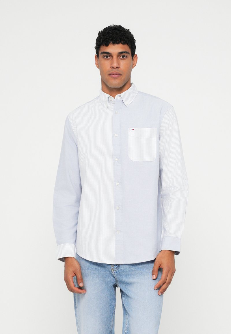 Πουκάμισο με κουμπιά, με αριστερή συμπαγή ανοιχτό μπλε πάνελ και δεξί πάνελ με λευκές ρίγες. Διαθέτει τσέπη και κανονικό для.