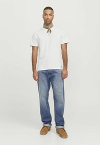 White cotton t-shirt, blue denim jeans, brown suede shoes, and a brown patterned scarf around the neck. Simple and casual design.