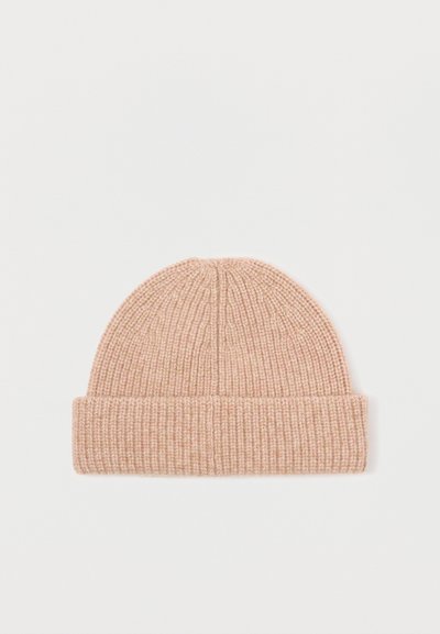 Knit kapa v svetlo roza barvi. Ima rebrasto teksturo, zložljiv rob in zasnovo z ozkim vrhom. Primerna za nošenje v hladnem vremenu.
