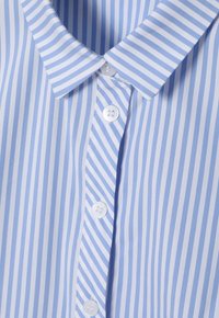 Chemise boutonnée rayée bleu clair avec un col classique, présentant de fines rayures blanches et bleu foncé, et des boutons blancs sur le devant.