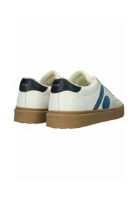 Zapatillas blancas de corte bajo con detalles en ante azul, lengüetas traseras negras, suelas de goma color canela y forro interior suave de color crema.