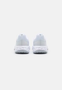 Des chaussures de sport blanches avec une tige en mesh et des accents gris clair, dotées d'une semelle rembourrée et d'un motif de bande de roulement texturé sur la semelle extérieure.