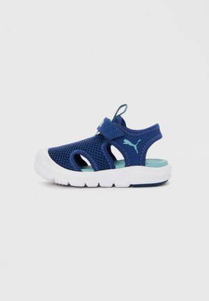 Sandalo sportivo per bambini blu e turchese con tomaia in mesh, cinturino regolabile, suola imbottita e logo Puma sul fianco.