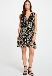 Zwarte jurk met een v-hals en mouwloos ontwerp, met een beige bladerenprint en een gerimpelde zoom. Draag met zwarte sandaaltjes met bandjes.