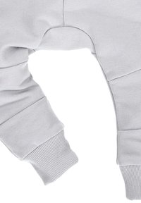 Lichtgrijze sweatshirt met geribbelde manchetten, een gladde textuur en een ontspannen pasvorm. Beschikt over een unieke uitsnede nabij de tailleband.