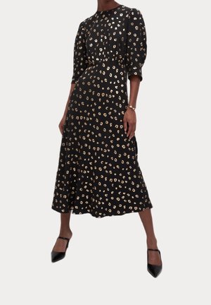 Robe noire avec un corsage ajusté, des manches bouffantes jusqu'au coude et une jupe fluide. Présente un motif léopard doré sur toute la surface.
