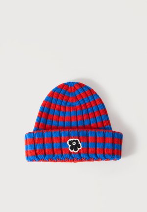 Bonnet tricoté rayé rouge et bleu avec revers et petit patch fleur noir et blanc au centre devant.