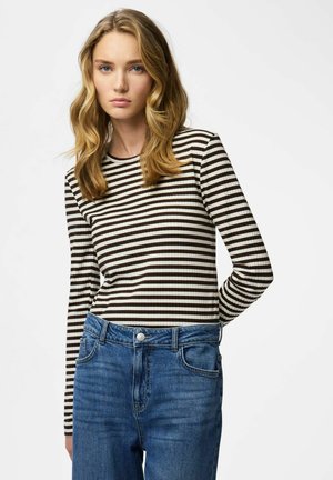 Maglia a maniche lunghe con righe orizzontali marroni e crema, con texture a coste. Abbinata a jeans di denim blu, con tasche e chiusura con bottoni.